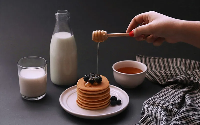 عکاسی محصول حرفه‌ای با ترکیب‌بندی خلاقانه شامل نورپردازی دقیق، کنتراست رنگی قوی بین محصول و پس‌زمینه و استفاده از عناصر مکمل برای روایت داستان برند