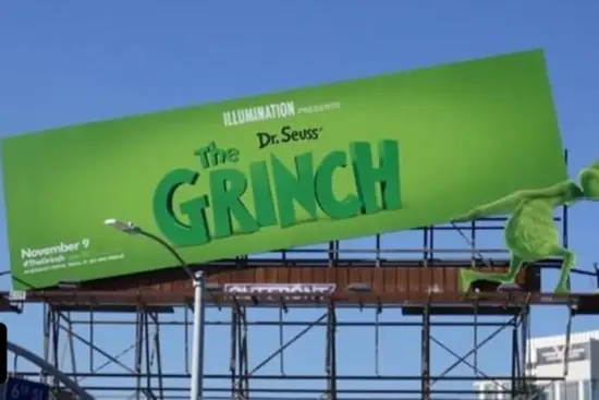 بیلبورد تبلیغاتی انیمیشن گرینچ که شخصیت گرینچ آن را به شکلی خلاقانه حمل می‌کند، نمونه‌ای از تبلیغات محیطی نوآورانه و تاثیرگذار