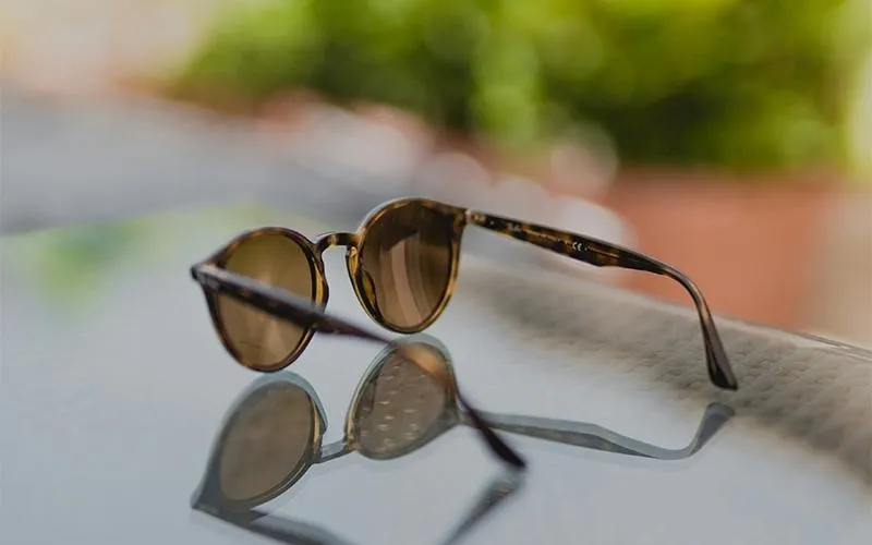 عکسی خلاقانه از یک عینک آفتابی روی آینه که با ترکیب چند زاویه و بازتاب‌ها گرفته شده و حس هنری و منحصر‌به‌فرد بودن برند را منتقل می‌کند