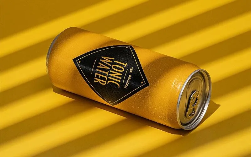 قوطی نوشیدنی زرد روی پس‌زمینه زرد، نمایش خلاقانه محصول در عکاسی فروشگاهی